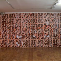 ŁADNE I ORYGINALNE  2004, plakat, 46x63 cm w dwóch kolorach, naklejony w 3 warstwach na ścianę - ok. 2,5 x5 m i zdzierany. Wystawa indywidualna „Obłożenie”, galeria Kronika w Bytomiu.