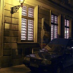 UCIEKAJ, 2003, druk na folii samoprzylepnej. Zaklejone okna galerii Szarej w Cieszynie w czasie wystawy „Borders and Beyond”  poświęconej nielegalnemu przekraczaniu granic.