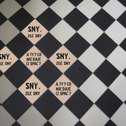 „Złe sny“, 2012, naklejki 10x10 cm na podłodze dworca PKP w Tarnowie, w czasie wystawy „Sen jest drugim życiem“, BWA Tarnów