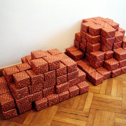 ŻYCIE ZMARNOWANE/DAWNO I NIEPRAWDA, 2002, druk na papierze offsetowym, pudełka( 13x15x8cm) opakowane w papier z napisami , ułożone w 2 stosy, po 100 sztuk.