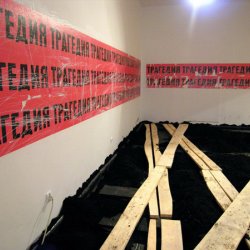 TRAGEDIA, 2004, plakaty z napisami po polsku i rosyjsku (na podłodze instalacja D. Gutowa) Wystawa zbiorowa „Za czerwonym horyzontem”, CSW Zamek Ujazdowski w Warszawie.