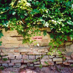 Lauf weg/ Uciekaj, 2004, tabliczka 8x 20cm, sitodruk, ok. 40 tabliczek na terenie twierdzy Kostrzyń w czasie projektu Dialog Loci w Kostrzynie na granicy polsko niemieckiej.